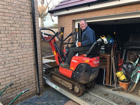 using a mini digger to clear a garden|mini digger hire near me.